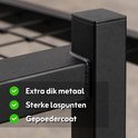 Detailopname van een zwart metalen bedframe met tekst: Extra dik metaal, Sterke laspunten, Gepoedercoat.