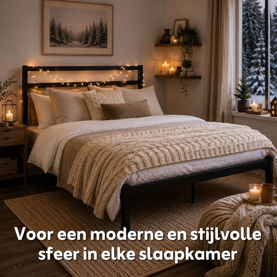 Zwart metalen bedframe met kerstverlichting in een sfeervol ingerichte slaapkamer.
