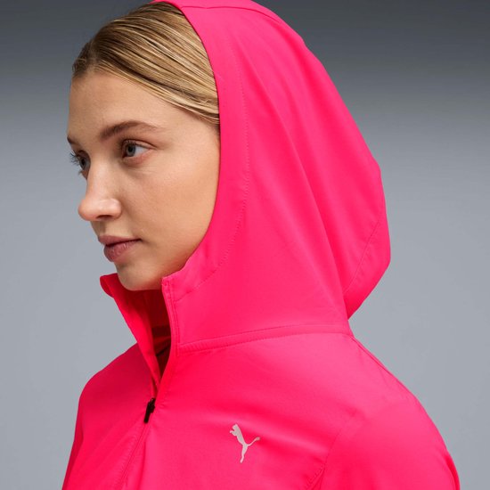Vrouw, zijaanzicht, felroze jas met capuchon en Puma-logo.