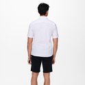 Man met wit kortarmig overhemd, getoond van achteren, met zwarte shorts.