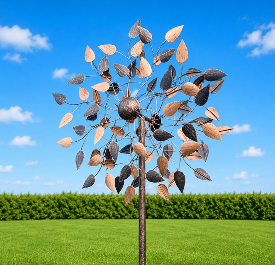 Windmolen met koperkleurige en donkere bladeren, geplaatst in een groene tuin met blauwe lucht.