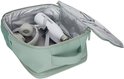 Open mintgroene tas met witte waterfles, koptelefoon en documenten erin.