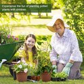 Oma en kleindochter planten samen in de tuin met decoratieve gouden plantenrekken.