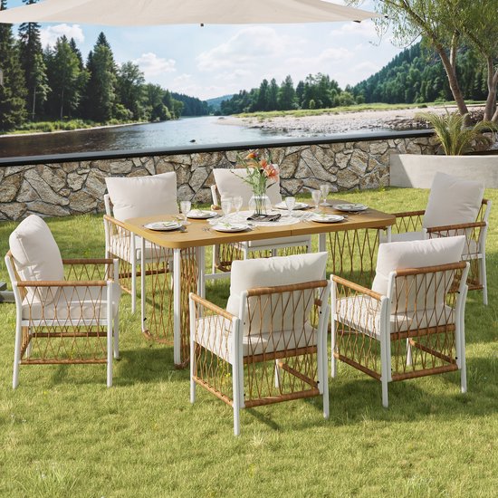 Eettafelset met zes stoelen met rotanlook zittingen en rugleuningen, witte metalen frame, beige kussens. Buiten setting.