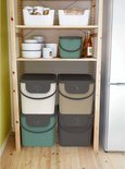 Stelling met diverse opslagbakken en containers in pastelkleuren.