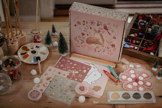 Knutseldoos 'Fairy Garden' met waterverf, kwast, kleurpotloden, stickers, mozaïekpakket en kartonnen vormen op een houten tafel.