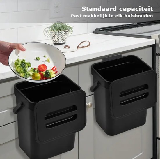 Twee zwarte compostbakken hangen aan keukenkastjes. Een hand doet groenten in de linkerbak.