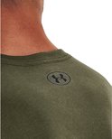 Detail van een donkergroen Under Armour sportshirt met logo op de schouder.