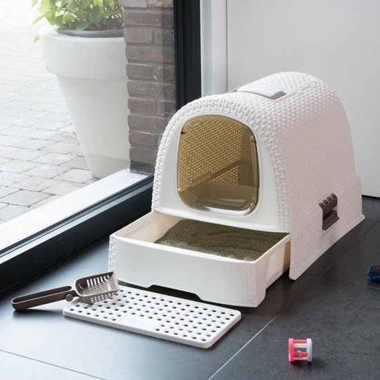 Crème kattentoilet met lade, geweven patroon, bruine handgreep, ovaal raam, met schep en mat voor de deur.