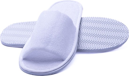 Pantoufles d'hôtel blanches en tissu éponge, bout ouvert. Les semelles sont grises et présentent un motif à chevrons.