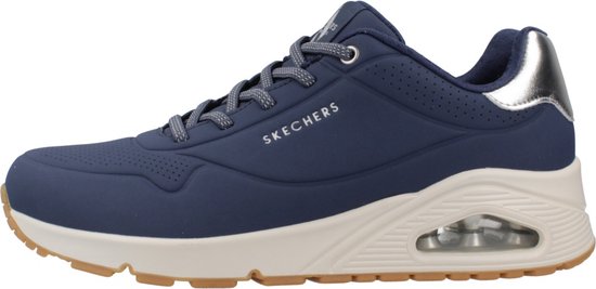 Donkerblauwe Skechers damessneaker met zilverkleurige hielkap, beige tussenzool en bruine rubberen buitenzool.