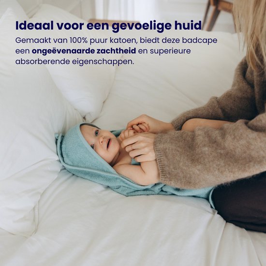 Mère avec bébé dans une cape de bain bleue sur un lit, "Idéal pour les peaux sensibles" est écrit en texte.