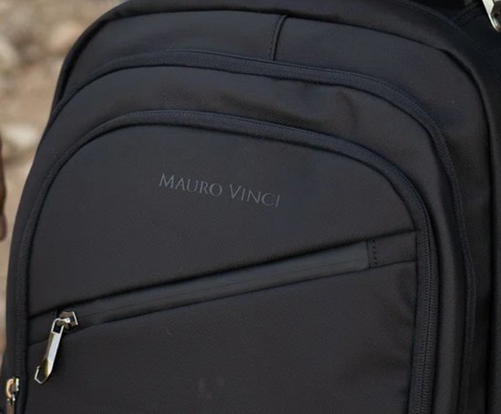 Close-up van de zwarte rugzak met 'MAURO VINCI' logo en ritsvak.