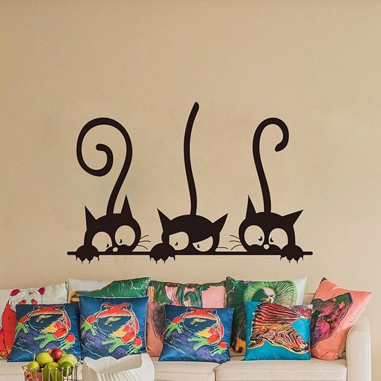 Zwarte katten sticker op een muur boven sierkussens met kattenprints.