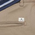 Detailopname van de achterzak van een beige chino broek met het Jack & Jones logo.