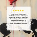 Fragment d'une peinture sur verre montrant deux silhouettes d'enfants et un ballon rouge. Une critique avec des étoiles jaunes est affichée.