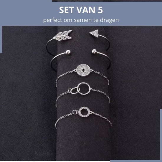Set van 5 zilverkleurige armbanden met pijlen, cirkels en sterren, gepresenteerd op een zwarte ondergrond.