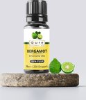 Qure Bergamot Etherische Olie flesje op een stenen sokkel met 2 bergamotvruchten. 10ml, 100% puur.