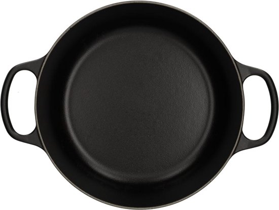 Zwarte gietijzeren braadpan, van bovenaf gezien, met twee handgrepen.