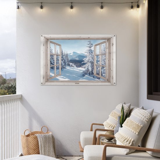 Fenêtre trompe-l'œil sur paysage de montagne enneigé, accrochée à un mur extérieur blanc.