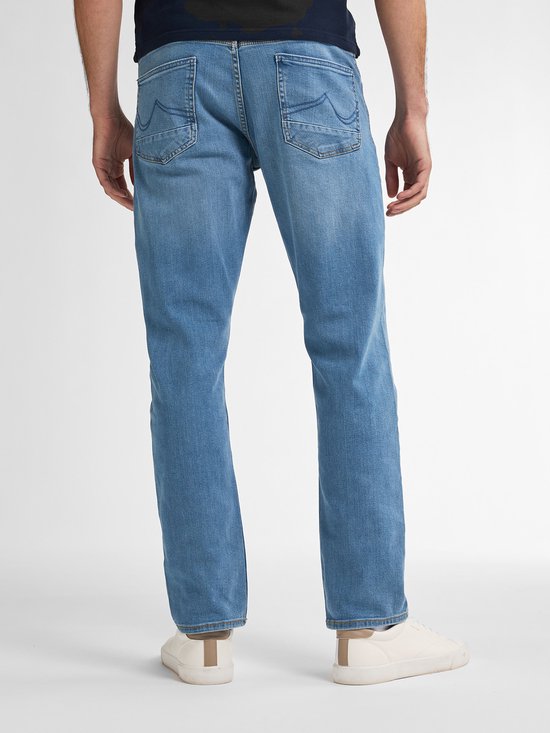 Man in lichtblauwe jeans, met de achterkant naar de camera gericht.