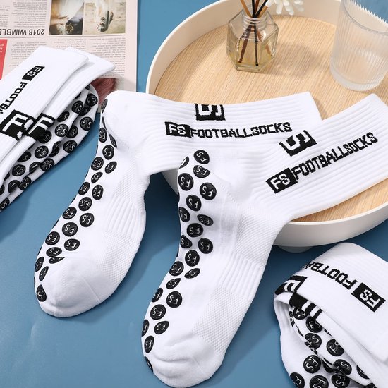 Chaussettes de sport blanches avec inscription noire 'FS FOOTBALL SOCKS' et picots antidérapants sur la semelle.