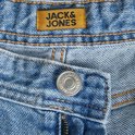 Detail van de tailleband van een spijkerbroek met een oranje Jack & Jones label en een zilveren knoop.