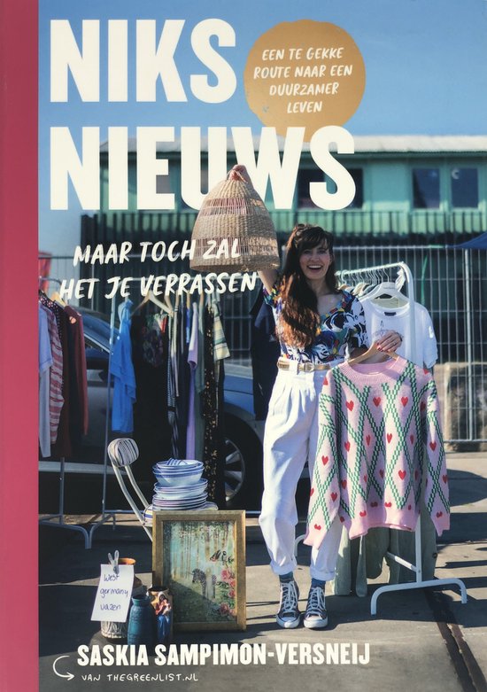 Vrouw met lang bruin haar, die een gebreide trui met hartjes vasthoudt voor een kleerrek.