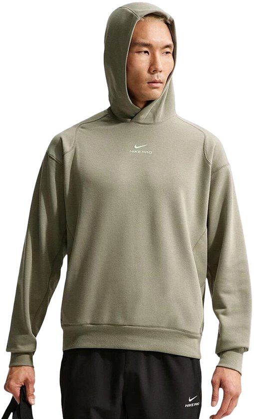 Model draagt een olijfgroene Nike Pro hoodie met klein logo en Nike Pro tekst op de borst.