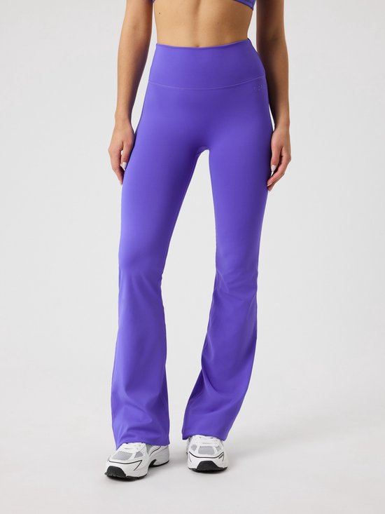 Paarse wijde sportbroek met hoge taille, gedragen door een model op witte achtergrond.