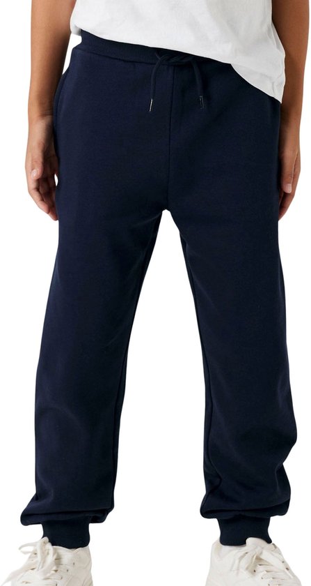 Onderlichaam van een jongen in een donkerblauwe joggingbroek met koord.
