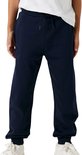 Onderlichaam van een jongen in een donkerblauwe joggingbroek met koord.