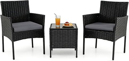 Zwarte rotan stoelen met grijze kussens en een vierkante bijzettafel met glasplaat, geserveerd met gebak en sap.