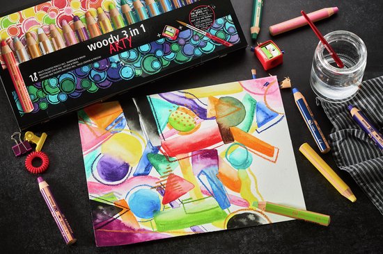 Een doos met 18 STABILO woody 3 in 1 ARTY potloden, naast een aquareltekening en losse potloden.