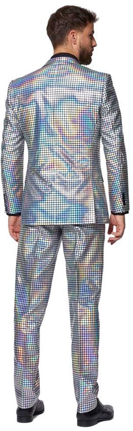Man in een zilveren discobroekpak met vierkante, glimmende patronen die licht reflecteren in regenboogkleuren, van achteren gezien.