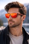 Man met zonnebril met oranje spiegelende glazen en houten pootjes. De reflectie toont bergen.