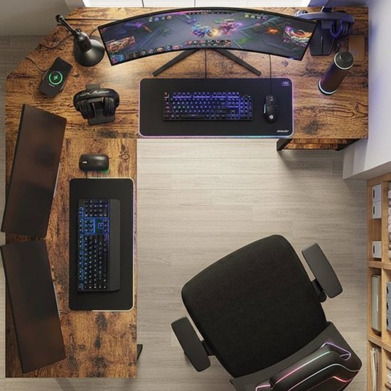 Gedetailleerde top-down weergave van een L-vormig bureau met gaming-opstelling: gebogen monitor, toetsenbord, muis, headset, lamp en computer.