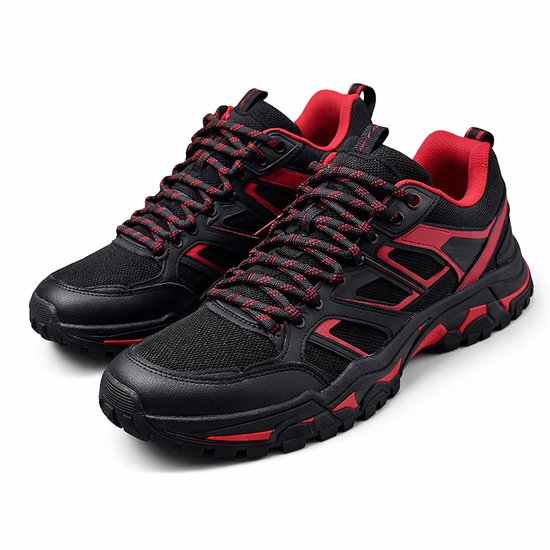 Zwarte lage sneakers met rode accenten en veters op een witte achtergrond.