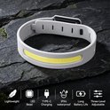 Grijze hoofdlamp van siliconen met gele LED-strip en verstelbare band, geplaatst op stenen. Lichtgewicht, LED, Type-C, IPX4, lange batterijduur, 3-niveaus.