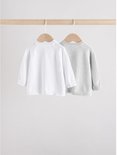 Twee babyvestjes, wit en lichtgrijs, hangend aan houten hangers.