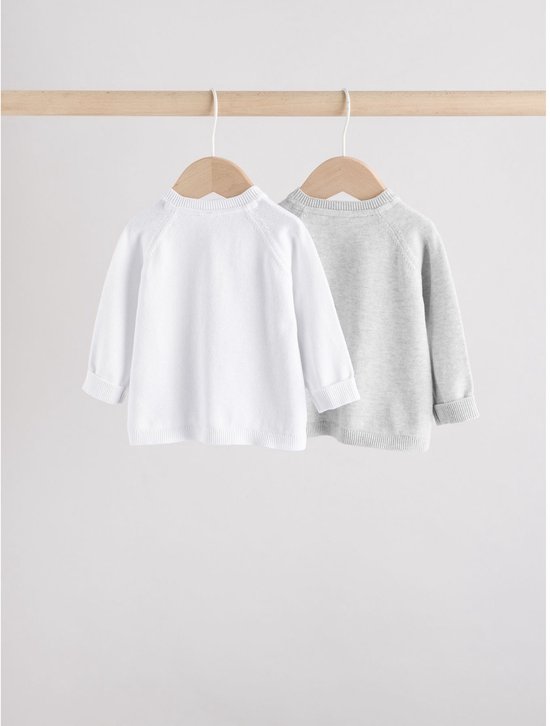 Twee babyvestjes, wit en lichtgrijs, hangend aan houten hangers.