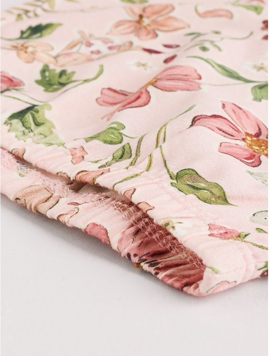 Zoom van een roze legging met bloemenprint, met ruche detail.