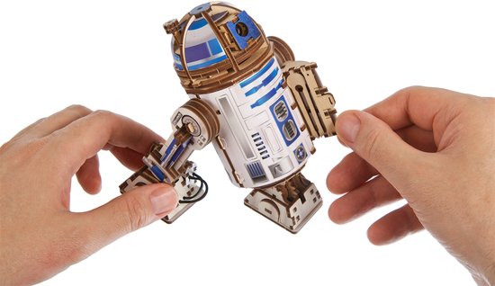 Handen monteren een arm van de houten R2-D2 modelbouwkit.
