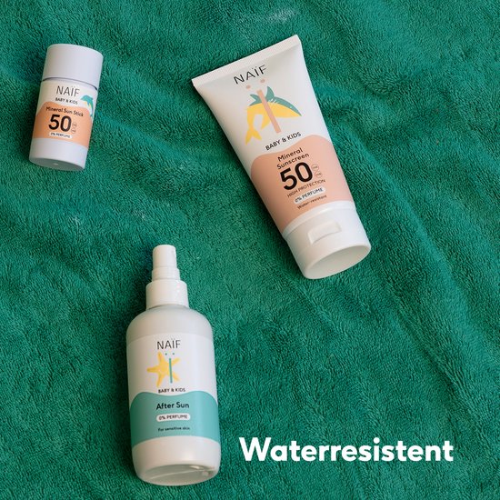 Drie Naïf baby zonnebrandproducten op groene handdoek. Met tube en spray.