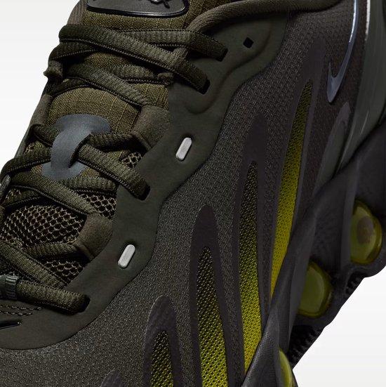 Detail van donkergroene Nike Air Max sneaker met gele strepen en luchtkussens.