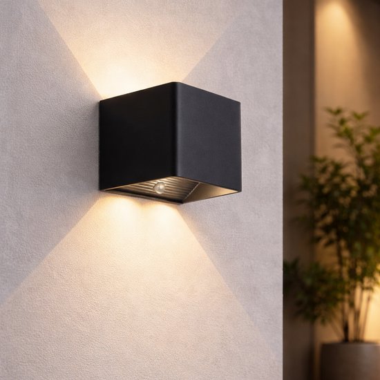 Moderne zwarte kubusvormige wandlamp met warme witte verlichting naar boven en beneden.