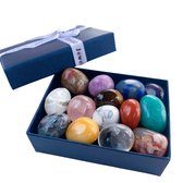 Een blauwe geschenkdoos met deksel geopend, met daarin 14 gepolijste edelstenen in diverse kleuren en patronen.