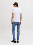 Jongens jeans in lichte wassing, gedragen door een model met witte T-shirt, gezien van achteren.