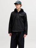 Man met zwarte softshell jas met capuchon, open rits en 'JJ Studio. Jack & Jones' logo, op witte achtergrond.