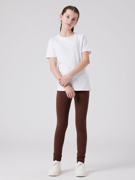 Meisje met een witte T-shirt en bruine legging.